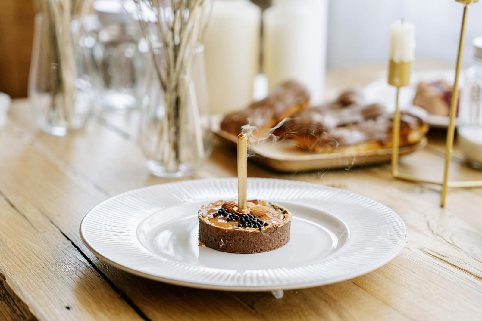 A Close-Up Shot of a Tart with a Candle on a Plate