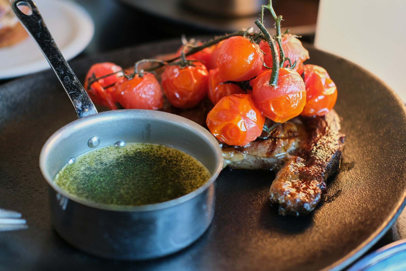 a plate with some meat and some tomatoes on it